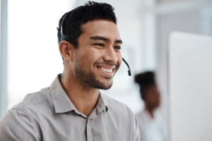 Male customer service agent on headset, smiling