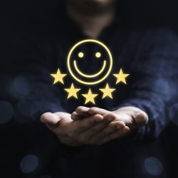 Businessman holding smile icon for the best evaluation , customer satisfaction concept.