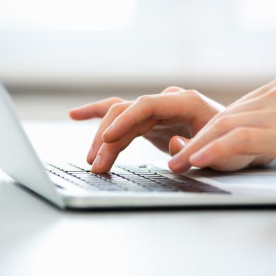 Hands typing on computer